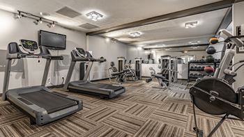 A gym with treadmills, exercise bikes, and other equipment